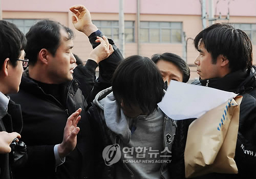 부산 여중생 납치 살해 피의자 김길태 씨가 10일 오후 수사본부가 차려진 사상경찰서로 연행되면서 한 시민에 의해 뒤통수를 얻어맞고 있다. 김 씨는 이날 부산 사상구 덕포시장 한 빌라 주차장 앞에서 사건발생 15일만에 경찰에 검거됐다. 2010.3.10. ccho@yna.co.kr